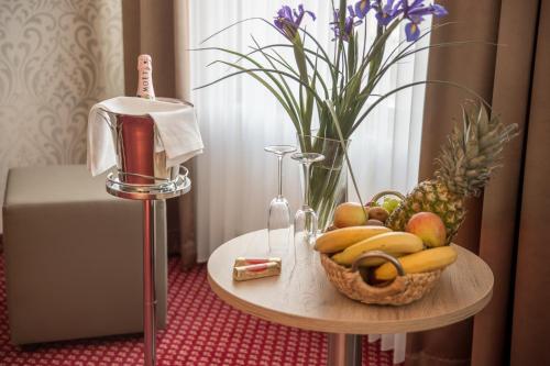 a table with a basket of fruit and a vase of flowers at Hotel Schwarzer Adler Tangermünde in Tangermünde