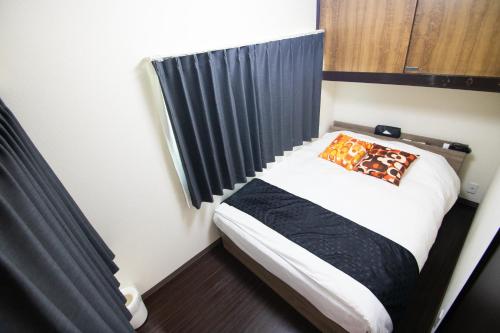 a small bed in a room with a black curtain at Omori Tei大森亭OMT 18min to Haneda, 3min Omori, Max 7 people in Tokyo