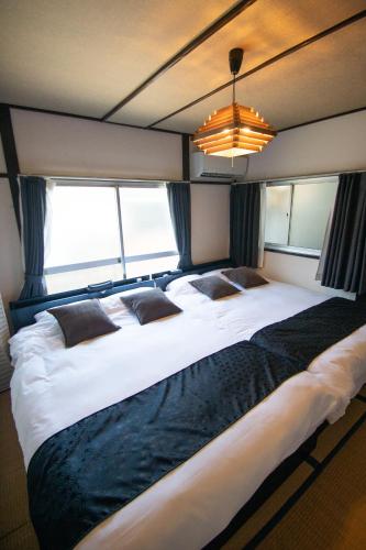 a large bed in a room with windows at Omori Tei大森亭OMT 18min to Haneda, 3min Omori, Max 7 people in Tokyo