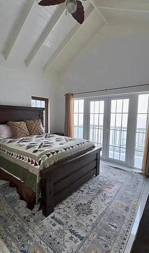 a bedroom with a bed in a room with windows at Sunset Serenity 2BR Oceanview Beach & Pool Access 