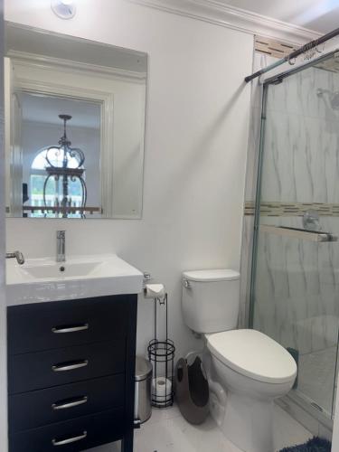 a bathroom with a toilet and a sink and a shower at Sunset Serenity 2BR Oceanview Beach & Pool Access 