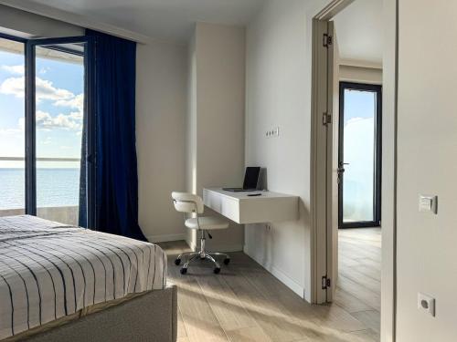 een slaapkamer met een bureau en een bed met een computer bij Bamboo Beach Tsikhisdziri in Tsikhisdziri