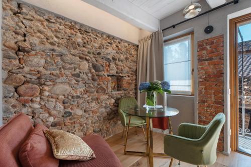 a living room with a brick wall and a table and chairs at Decanter House in Borgomanero