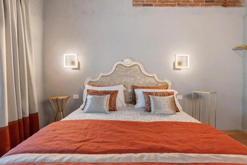a bedroom with a large bed with orange and white pillows at Decanter House in Borgomanero
