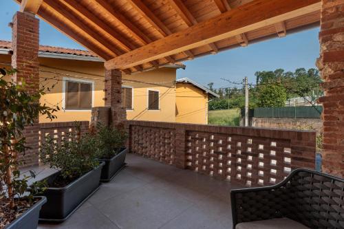 a patio with a wooden pergola and some plants at Decanter House in Borgomanero