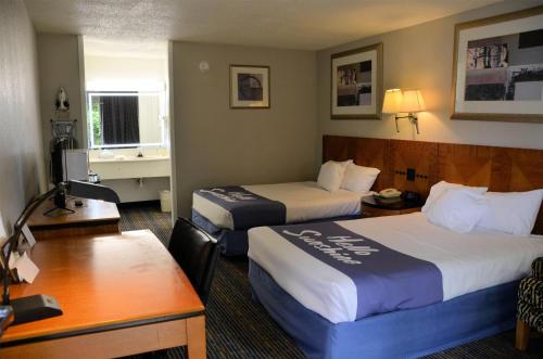 a hotel room with two beds and a desk at Days Inn by Wyndham Luray Shenandoah in Luray