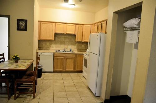 a kitchen with wooden cabinets and a white refrigerator at Days Inn by Wyndham Luray Shenandoah in Luray