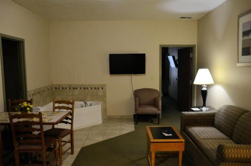 a living room with a couch and a tv on the wall at Days Inn by Wyndham Luray Shenandoah in Luray