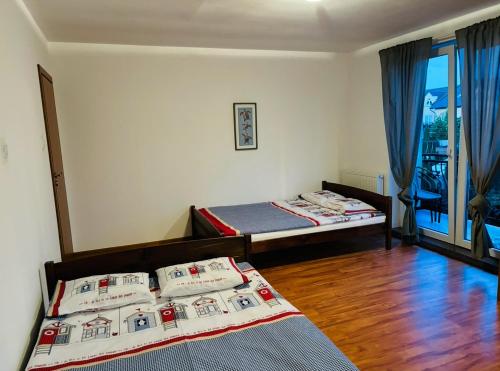 ein Zimmer mit zwei Betten und einem Fenster mit blauen Vorhängen in der Unterkunft Julus in Łeba