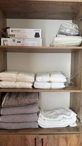 a shelf with towels and boxes in a closet at Agat Lake Cottage Issyk-Kul in Tong