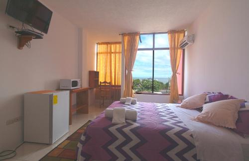 a bedroom with a large bed and a window at Hostal Tongo Reef in Puerto Baquerizo Moreno