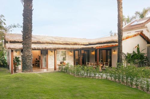 a house with a lawn in front of it at Palm Garden Beach Resort & Spa in Hoi An