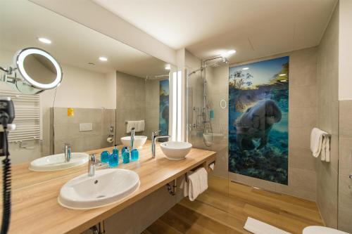 ein Badezimmer mit zwei Waschbecken und einem großen Wandgemälde in der Unterkunft Best Western Hotel Wiesbaden in Wiesbaden