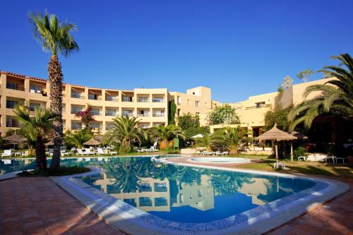 a hotel with a swimming pool in front of a resort at Hello Yasmine Hotel in Hammamet