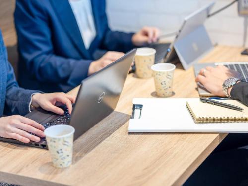 a group of people sitting at a table with their laptops at Comfort Hotel Takamatsu in Takamatsu
