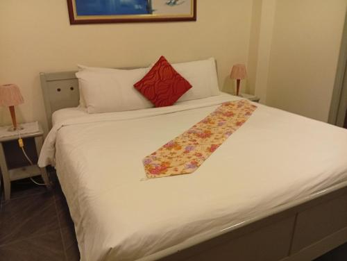 a bed with a white bedspread with a floral tie on it at Fantastic appartment at times square Kuala Lumpur in Kuala Lumpur
