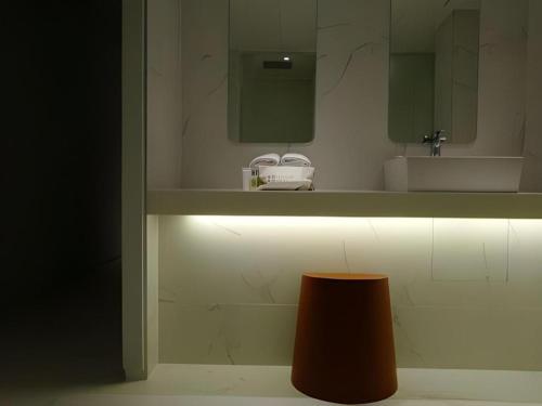 a bathroom with a sink and a mirror and a stool at Bobo Hotel Hongdae in Seoul