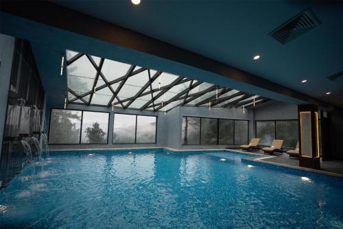 a large swimming pool with chairs in a building at Doubletree By Hilton Nathiagali in Nathia Gali