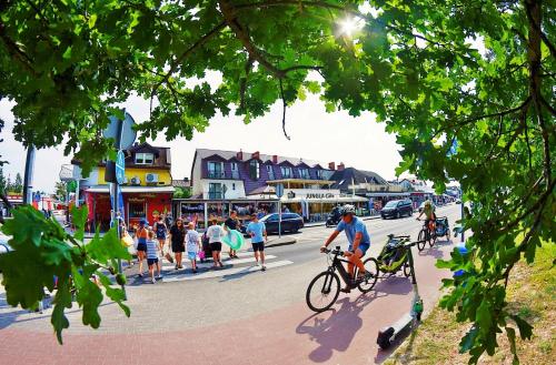 a group of people riding bikes down a street at OLECKI Holiday House in Dźwirzyno