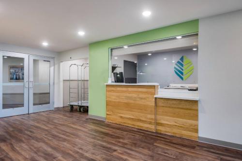 a room with a green and white wall and a mirror at WoodSpring Suites Tampa Airport North Veterans Expressway in Tampa