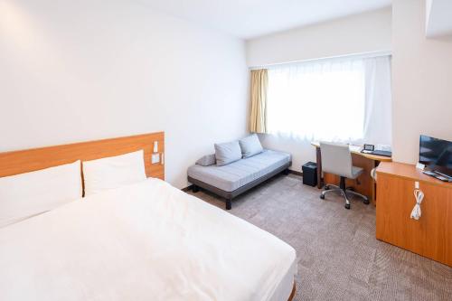a bedroom with a bed and a desk and a chair at Comfort Inn Himeji Yumesakibashi in Himeji