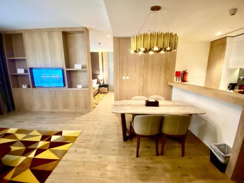 a kitchen and dining room with a table and chairs at The Bentley Luxury Hotel & Suites in Doha