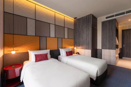 two beds in a hotel room with two beds sidx sidx sidx at Ramada Plaza by Wyndham Bangkok Sukhumvit 48 in Bangkok