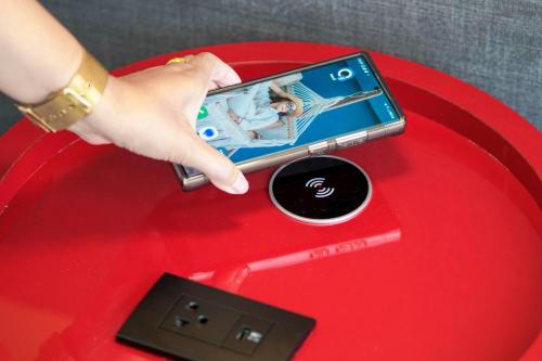 a person holding a cell phone on a red table at Ramada Plaza by Wyndham Bangkok Sukhumvit 48 in Bangkok