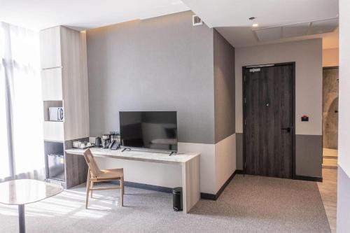 a room with a desk and a chair and a table at Ramada Plaza by Wyndham Bangkok Sukhumvit 48 in Bangkok