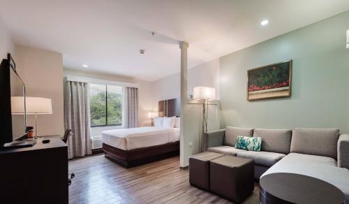 a hotel room with a bed and a couch at Comfort Inn & Suites Tobago in Tobago Island