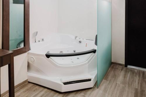 a bathroom with a white bath tub in a room at Comfort Inn & Suites Tobago in Tobago Island