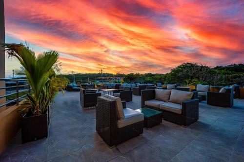 a patio with couches and tables and a sunset at Comfort Inn & Suites Tobago in Tobago Island