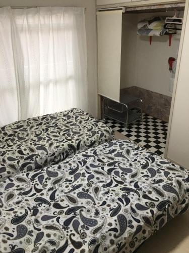 a bedroom with a bed with a black and white comforter at Utopia Wakamiya 207 / Vacation STAY 5372 in Fukuoka