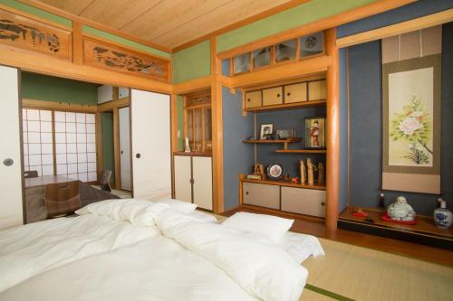 ein Schlafzimmer mit einem großen weißen Bett in einem Zimmer in der Unterkunft Matsuyama - House / Vacation STAY 57590 in Matsuyama