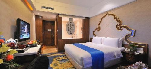 a hotel room with a bed and a television at Hohhot Inner Mongolia Hotel in Hohhot