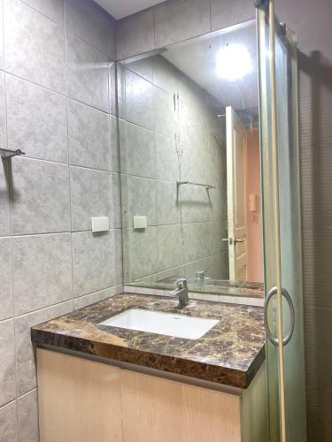 a bathroom with a sink and a mirror at Monarch Parksuites in Manila
