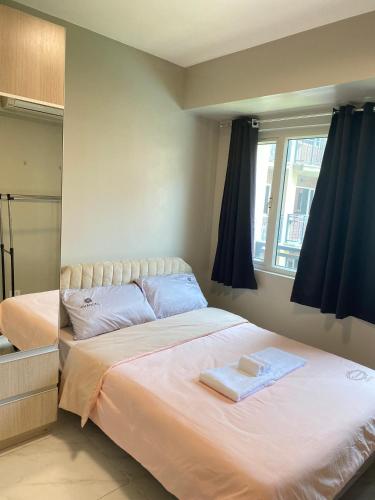 a bedroom with a large bed and a window at Monarch Parksuites in Manila