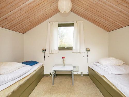 zwei Betten in einem Zimmer mit Tisch und Fenster in der Unterkunft 5 person holiday home in Martofte-By Traum in Nordskov