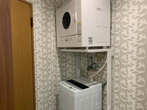 a kitchen with a microwave and a washing machine at AO Dazaifu / Vacation STAY 61736 in Chikushino