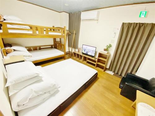 ein Schlafzimmer mit zwei Etagenbetten und einem Fernseher in der Unterkunft Petit Hotel 017 - Vacation STAY 36971v in Tokushima