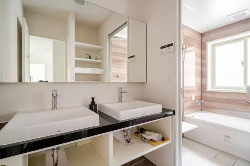 a bathroom with two sinks and a tub and a mirror at Naha - House / Vacation STAY 60932 in Naha