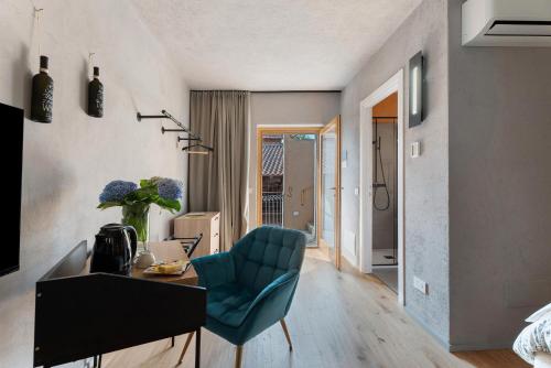 a room with a desk and a blue chair at Decanter House in Borgomanero