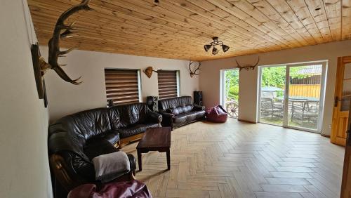 a living room with a leather couch and a table at Pilsētas rezidence in Jēkabpils
