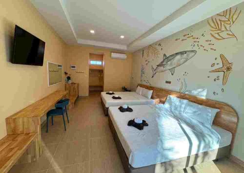 a hotel room with two beds and a tv at เดอะทอย บีช รีสอร์ท เดอะแมร์ in Ban Chek