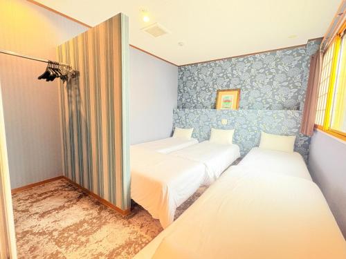 two beds in a room with blue walls at AO Dazaifu / Vacation STAY 61732 in Chikushino