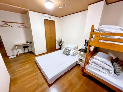 a bedroom with two bunk beds and a desk at Petit Hotel 017 / Vacation STAY 67155 in Tokushima