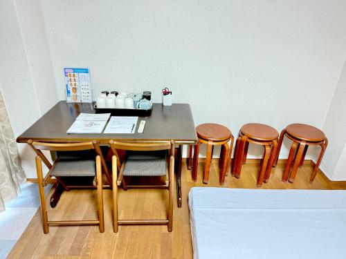 a dining room table with four chairs and a table at Petit Hotel 017 / Vacation STAY 67155 in Tokushima