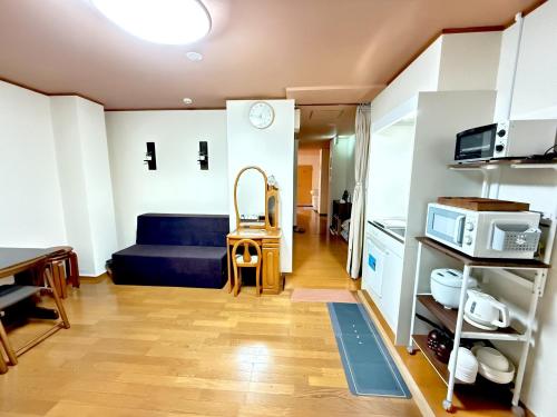 a living room with a blue couch and a kitchen at Petit Hotel 017 / Vacation STAY 67155 in Tokushima