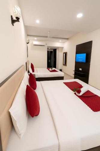 two beds in a hotel room with red pillows at Hotel JB Residency Zirakpur Chandigarh # Large Rooms # Balcony Rooms # Top Rated in Zirakpur