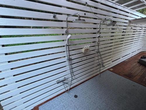 a wall with white blinds and a shower at SAUNA Log Village富津岬 in Futtsu